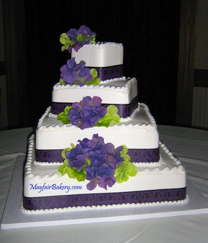 4 tier Alisa - 4 tier square with each tier turned slightly. Purple ribbon and flowers.4&quot;, 8&quot;, 12&quot;, 16&quot; tiers. 25 to 30 pounds. Serves 125 to 150.